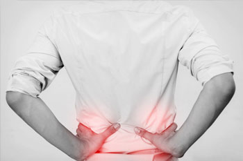 Person holding hips in pain, black and white image with red pain in hips